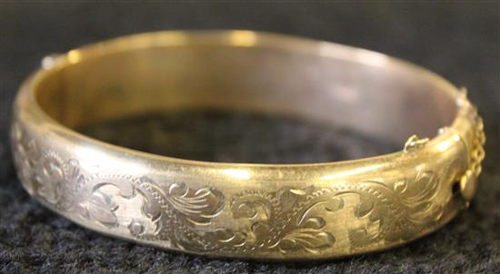 A 9ct gold half engraved stiff bangle